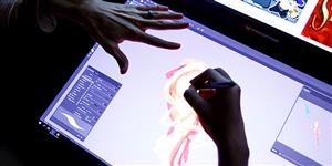 Hands drawing a digital design on a laptop